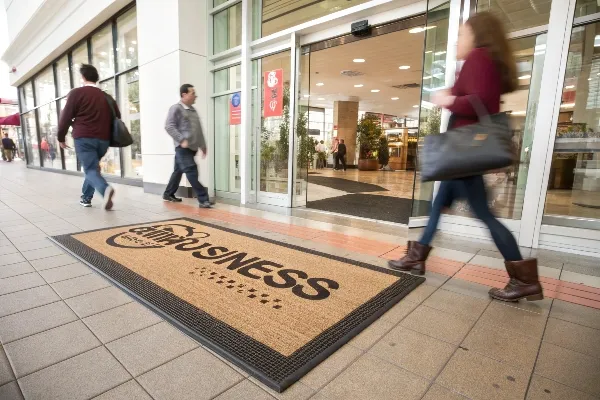 Custom commercial logo door mat at busy store entrance